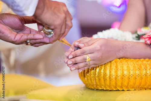 Hands pouring blessing water into bride's bands, Thai wedding. Wedding ceremony in Thailand.