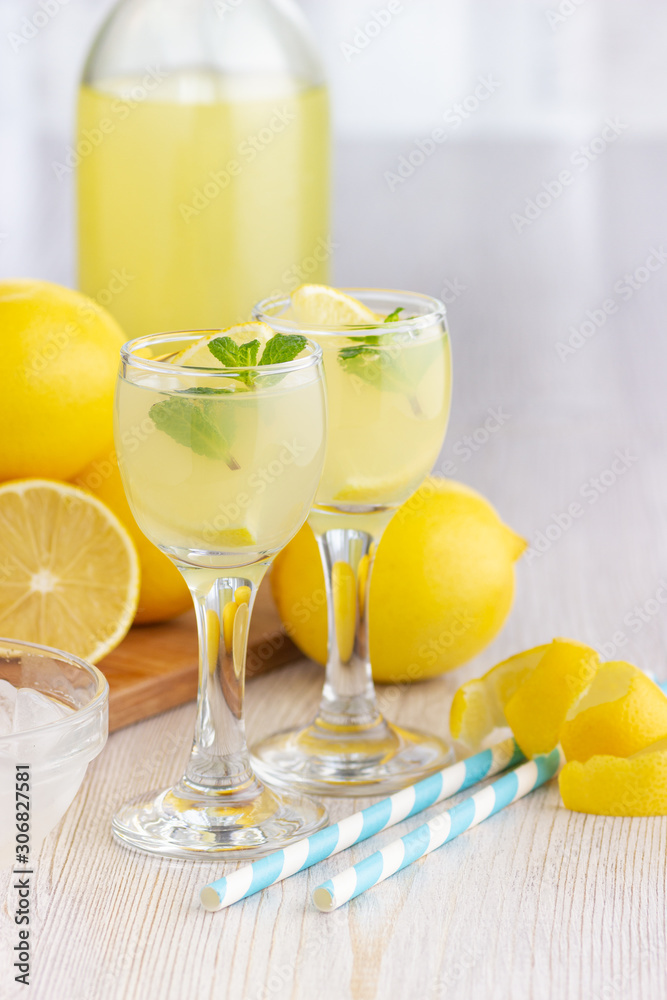 Alcohol cocktail drink with lemon, mint and ice in a small glass. Alcohol cocktail drink with lemon, mint and ice in a small glass.