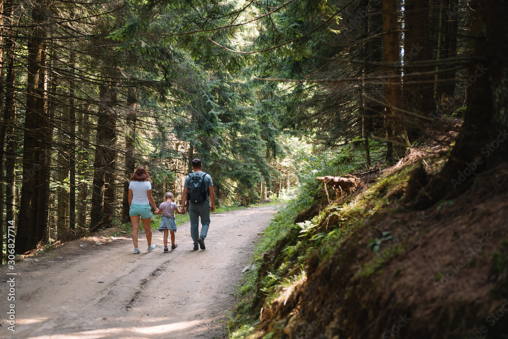 Young family with child resting on a forest