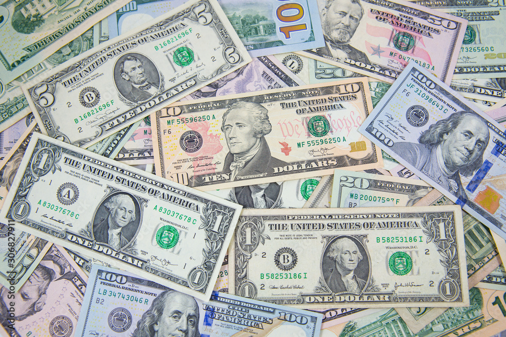 Money American dollar bills .Pile of various currencies isolated on white background. Closeup of assorted American banknotes.US currency scattered on the table. America currency. Money American dollar bills .Pile of various currencies isolated on white background. Closeup of assorted American banknotes.US currency scattered on the table. America currency.