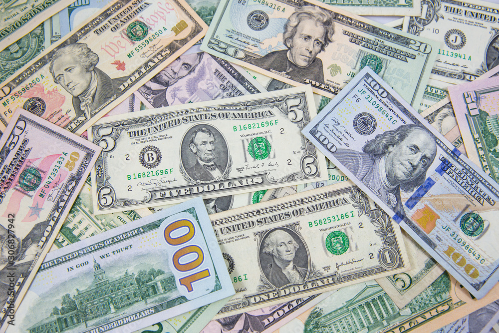 Money American dollar bills .Pile of various currencies isolated on white background. Closeup of assorted American banknotes.US currency scattered on the table. America currency. Money American dollar bills .Pile of various currencies isolated on white background. Closeup of assorted American banknotes.US currency scattered on the table. America currency.