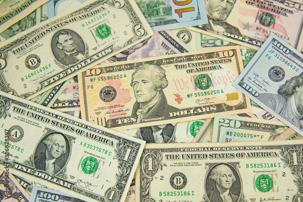 Money American dollar bills .Pile of various currencies isolated on white background. Closeup of assorted American banknotes.US currency scattered on the table. America currency. Money American dollar bills .Pile of various currencies isolated on white background. Closeup of assorted American banknotes.US currency scattered on the table. America currency.