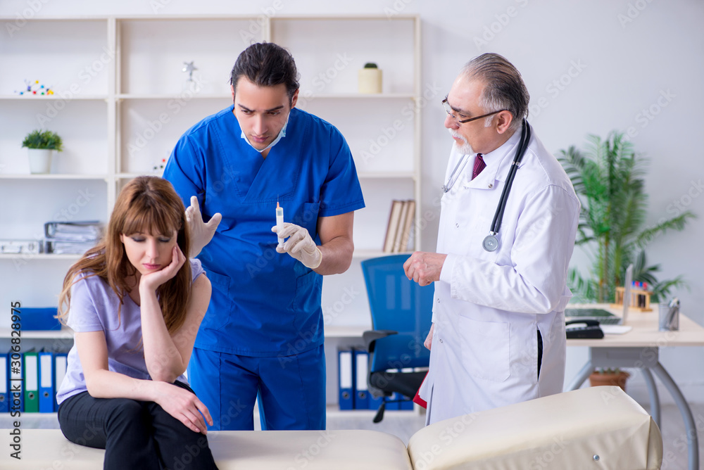 Fototapeta premium Two doctors examining young woman