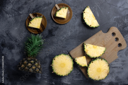 Slices of fresh Pineapple on simple grey background, from above. Top view. Copy space for designer.