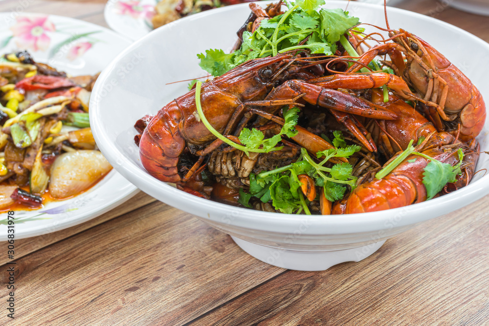 Chongqing Sichuan spicy dried chilli small lobsters, among other dishes in the background. Food photography at Chinese restaurant. Chongqing Sichuan spicy dried chilli small lobsters, among other dishes in the background. Food photography at Chinese restaurant.