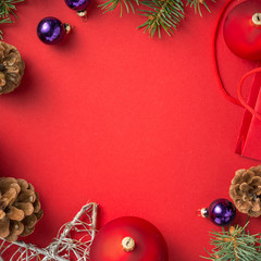 Frame of christmas decoration on red background top view
