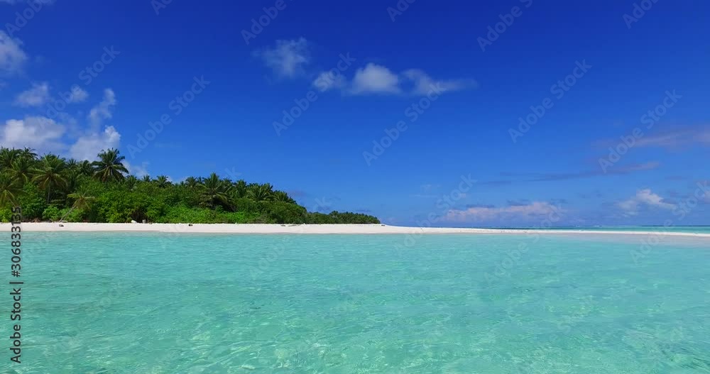 Vivid colors of tropical picture of island with lush vegetation and palm trees, white sandy beach washed by crystal emerald sea water under bright blue sky in Bahamas Vivid colors of tropical picture of island with lush vegetation and palm trees, white sandy beach washed by crystal emerald sea water under bright blue sky in Bahamas