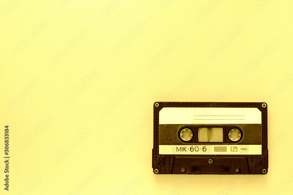 Obraz premium Old audio tape cassette, top view. Old technology concept. Yellow color toned