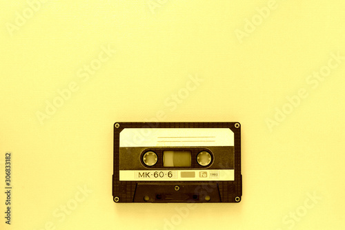 Old audio tape cassette, top view. Old technology concept. Yellow color toned