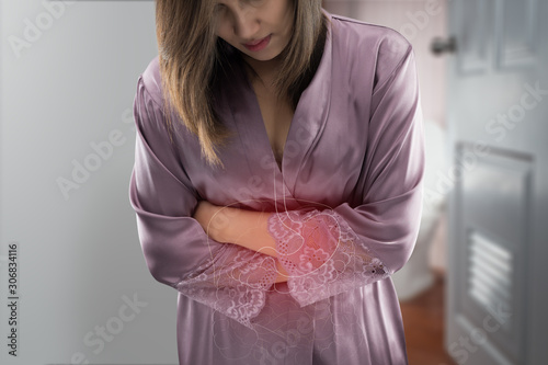 Photos The photo of stomach and large intestine is on the woman's body against gray bac