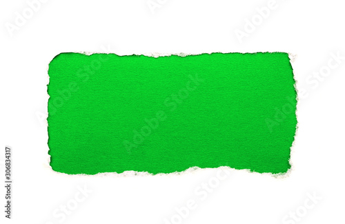 A hole in white paper with torn edges isolated on a white background with a bright green color paper background inside. Good paper texture