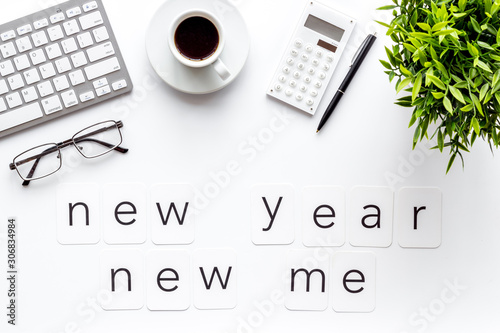 Plan concept. New year new me - motivation motto on white office desk top-down