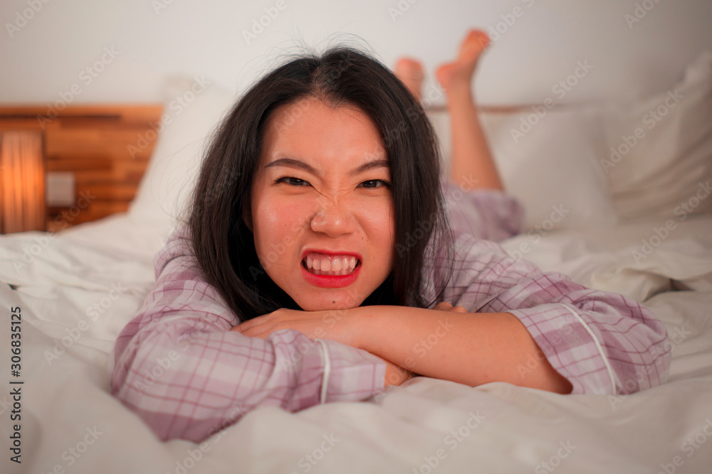 lifestyle portrait of young beautiful and sweet Asian Chinese woman in bed feeling happy and relaxed wearing cute pajamas enjoying lazy Sunday morning at home lifestyle portrait of young beautiful and sweet Asian Chinese woman in bed feeling happy and relaxed wearing cute pajamas enjoying lazy Sunday morning at home