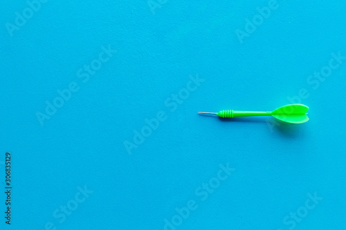 Plastic dart or arrows for darts game on blue background top view copy space