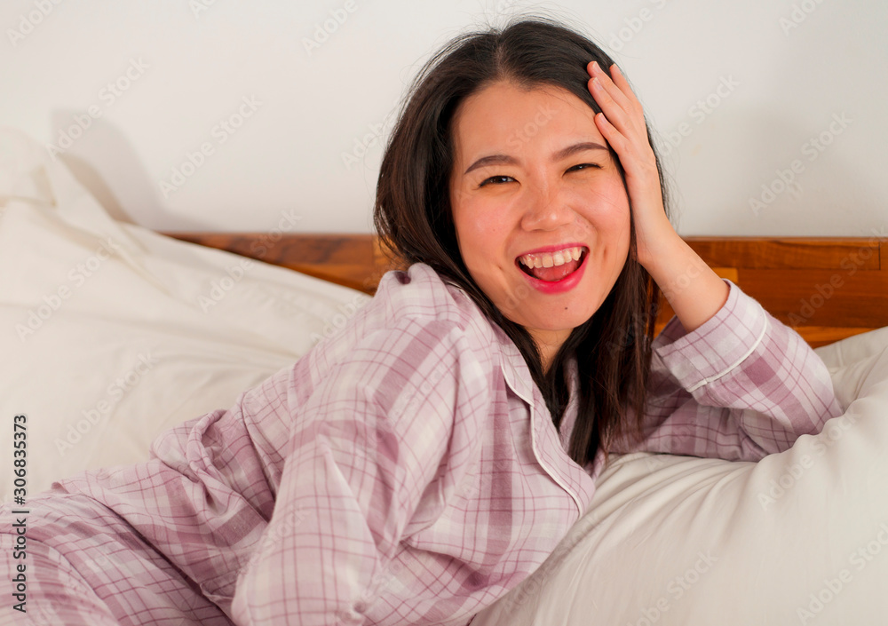 lifestyle portrait of young beautiful and sweet Asian Chinese woman in bed feeling happy and relaxed wearing cute pajamas enjoying lazy Sunday morning at home lifestyle portrait of young beautiful and sweet Asian Chinese woman in bed feeling happy and relaxed wearing cute pajamas enjoying lazy Sunday morning at home