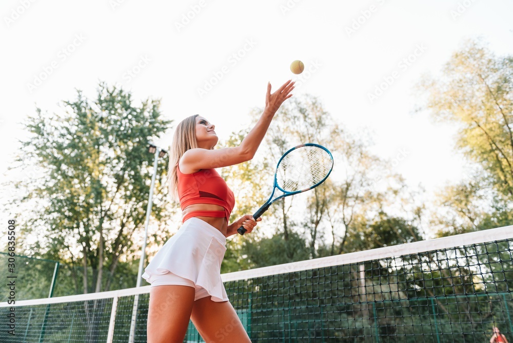 Woman in sportswear plays tennis at competition