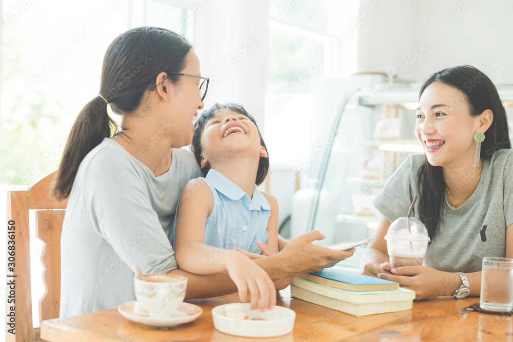 mother and daughter read a book drinking tea and cuddling in cafe mother and daughter read a book drinking tea and cuddling in cafe