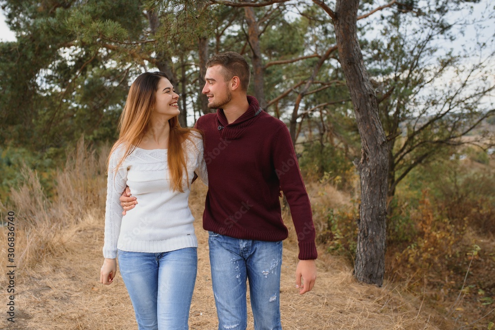 Couple in love lying on a picnic blanket in a park, enjoying beautiful autumn day in nature and cuddling Couple in love lying on a picnic blanket in a park, enjoying beautiful autumn day in nature and cuddling
