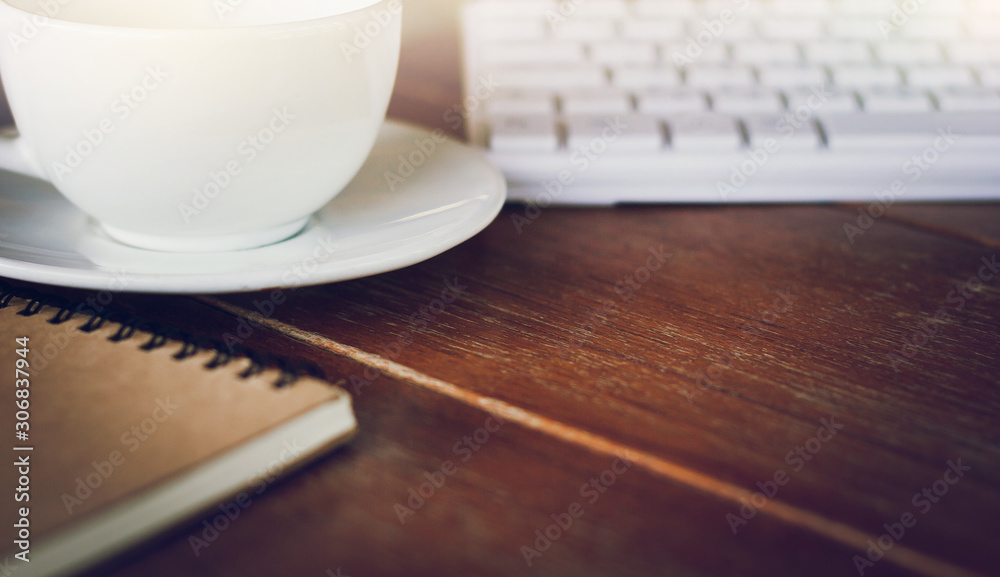 Place of work on desk with coffee cup, computer keyboard and notebook Place of work on desk with coffee cup, computer keyboard and notebook