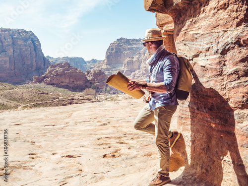 Handsome man, exploring the sights of the ancient, fabulous city of Petra in Jordan. Colorful photos. Concept of leisure, vacation and travel