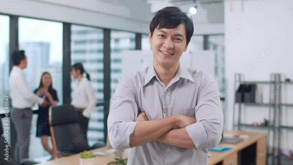 Portrait of successful handsome executive businessman smart casual wear looking at camera and smiling, arms crossed in modern office workplace. Young Asia guy standing in contemporary meeting room. Portrait of successful handsome executive businessman smart casual wear looking at camera and smiling, arms crossed in modern office workplace. Young Asia guy standing in contemporary meeting room.