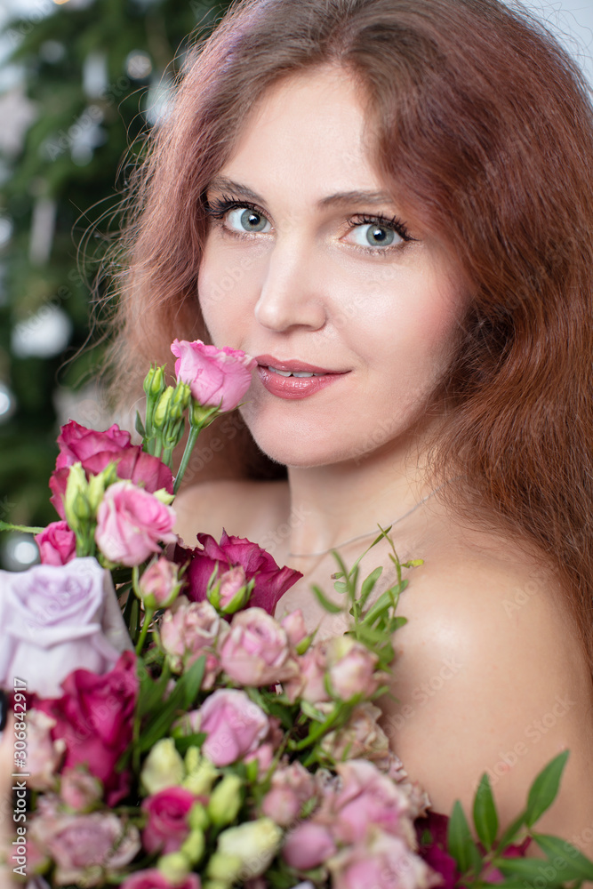 Vertical portrait of a beautiful long-haired woman with a bouquet of flowers