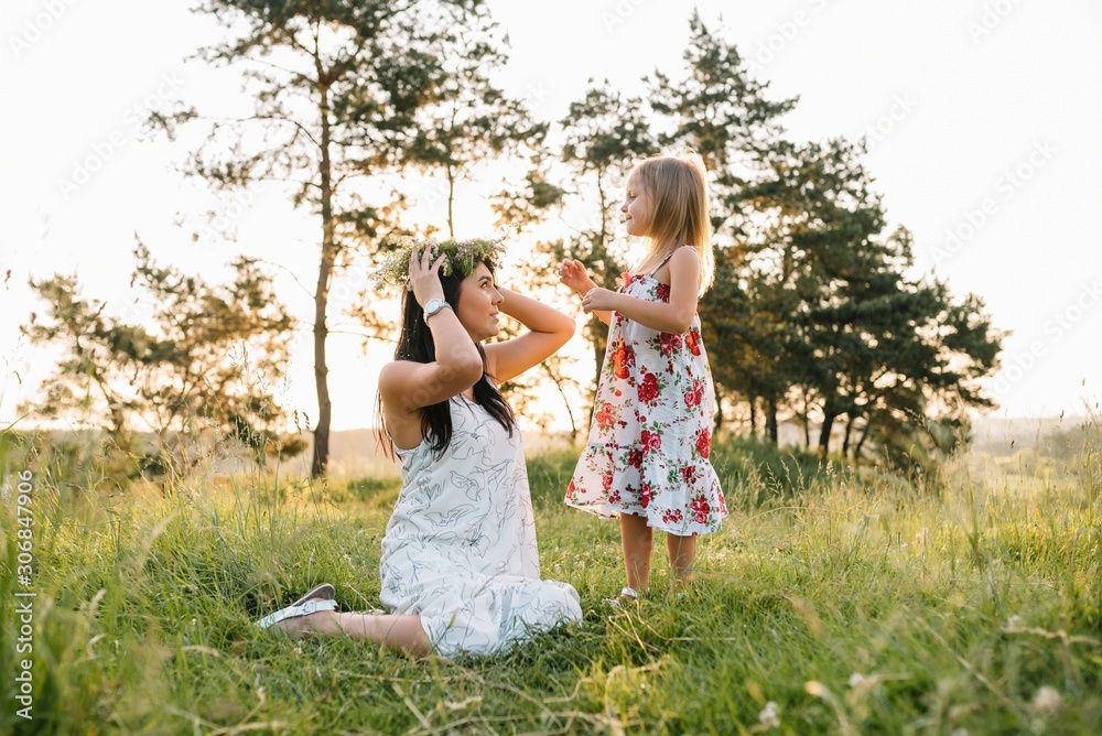 Obraz premium Stylish mother and handsome daughter having fun on the nature. Happy family concept. Beauty nature scene with family outdoor lifestyle. family resting together. Happiness in family life. Mothers day