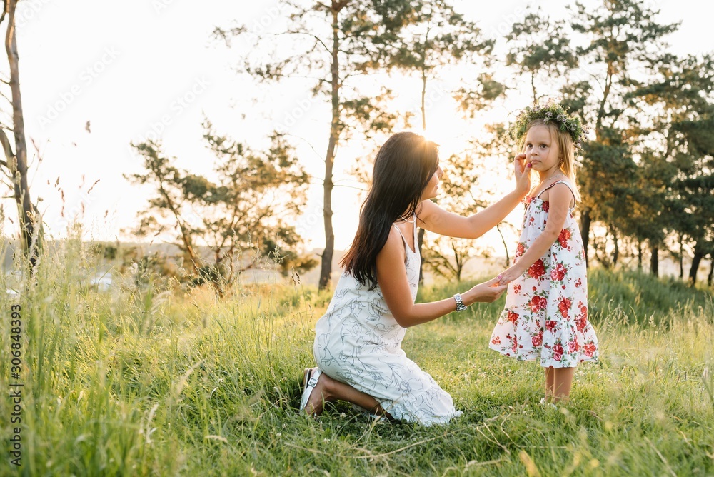 Mother and daughter having fun in the park. Happiness and harmony in family life. Beauty nature scene with family outdoor lifestyle. Mother and daughter having fun in the park. Happiness and harmony in family life. Beauty nature scene with family outdoor lifestyle.