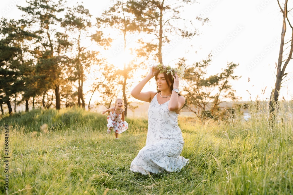 Mother and daughter having fun in the park. Happiness and harmony in family life. Beauty nature scene with family outdoor lifestyle. Mother and daughter having fun in the park. Happiness and harmony in family life. Beauty nature scene with family outdoor lifestyle.