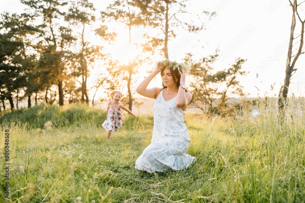 Stylish mother and handsome daughter having fun on the nature. Happy family concept. Beauty nature scene with family outdoor lifestyle. family resting together. Happiness in family life. Mothers day