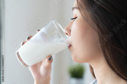 Healthy beautiful asian woman drinking plain fresh milk in the morning.