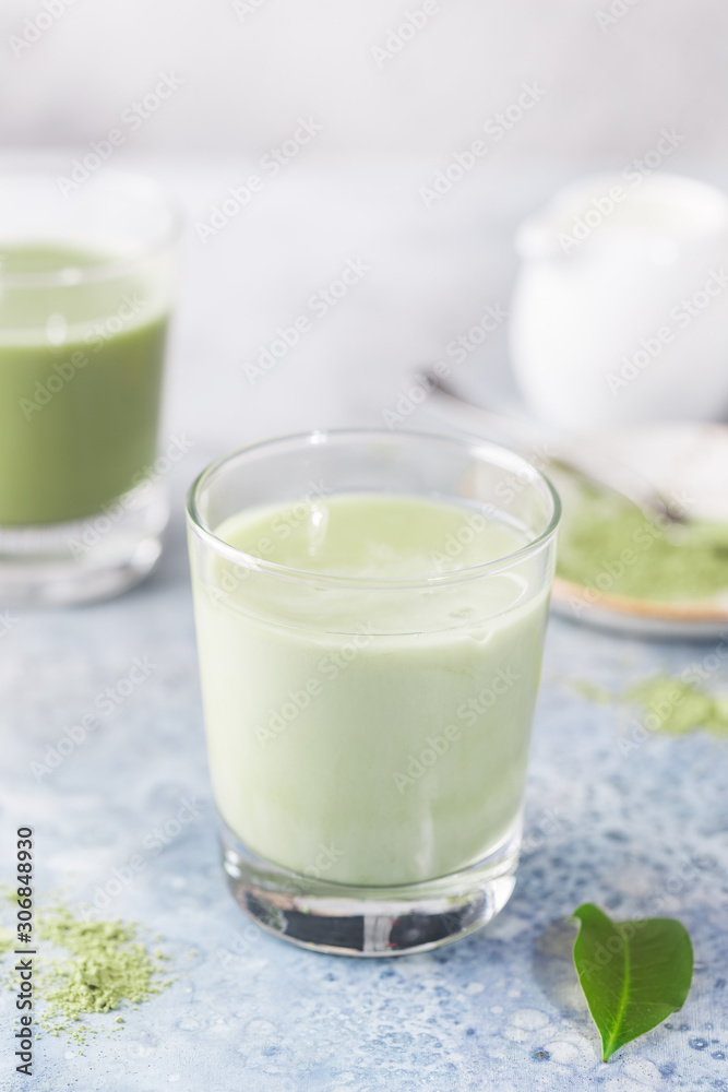 Iced Matcha green latte in glasses with matcha powder on light background. Iced Matcha green latte in glasses with matcha powder on light background.