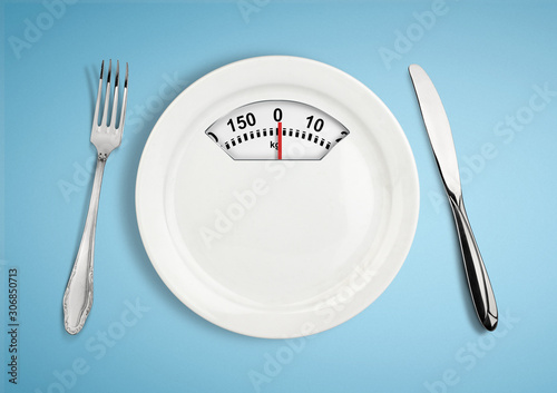 Diet and weight loss concept. Plate with scale weighing-machine