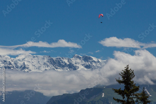 paragliding in Swiss alps in Bernese highlands, mountains, blue sky