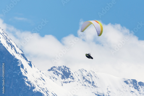flying paraglider in Swiss alps in Bernese highlands, mountains, snow