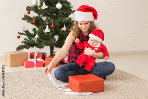 Family, childhood and Christmas concept - Portrait of happy mother and adorable baby in suit of Santa