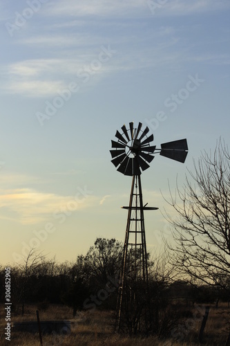 windmill at sunset with clouds and tree's