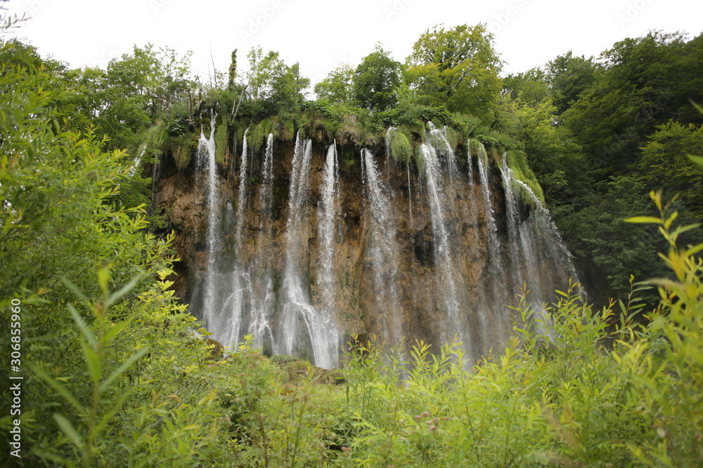 Landscape view on the waterfall in Plitvice Lakes National Park on a cloudy summer day. Nature background. Croatia.