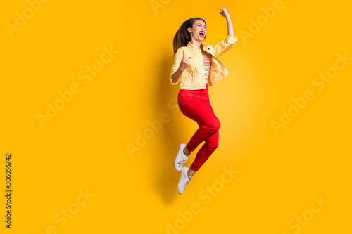 Full length body size photo of cheerful excited crazy woman rejoicing in having become able to jump in red pants screaming isolated vivid color background