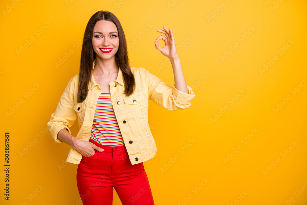 Photo of cheerful trendy cute nice pretty woman with pants and hand in pocket showing ok sign near empty space isolated vivid color background Photo of cheerful trendy cute nice pretty woman with pants and hand in pocket showing ok sign near empty space isolated vivid color background