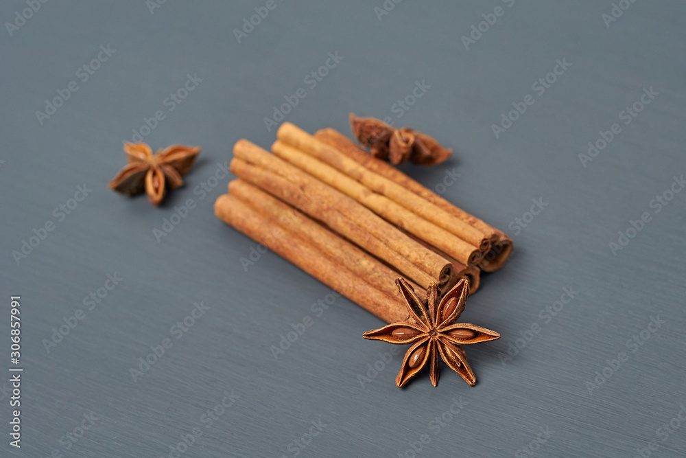 Heap of five flavour cinnamon sticks near stars of anise lies on dark scratched desk on kitchen. Close-up Heap of five flavour cinnamon sticks near stars of anise lies on dark scratched desk on kitchen. Close-up