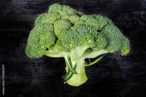 Head of fresh broccoli on the black surface