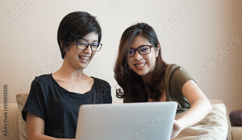 Two girls partner working on e-commerce business onine from home through computer together photo