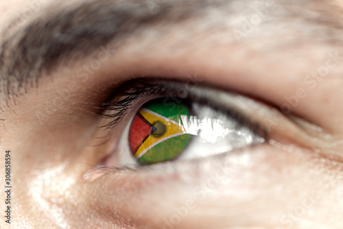 Flag of guyana reflects in a man brown eye - election, sport, hope, young, generation	 photo