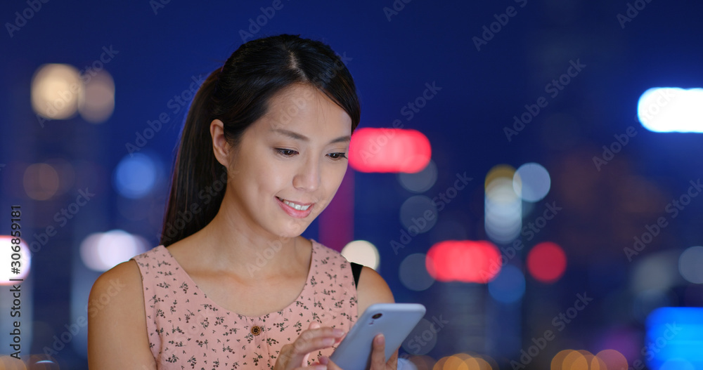 Woman use of mobile phone in city at night Woman use of mobile phone in city at night