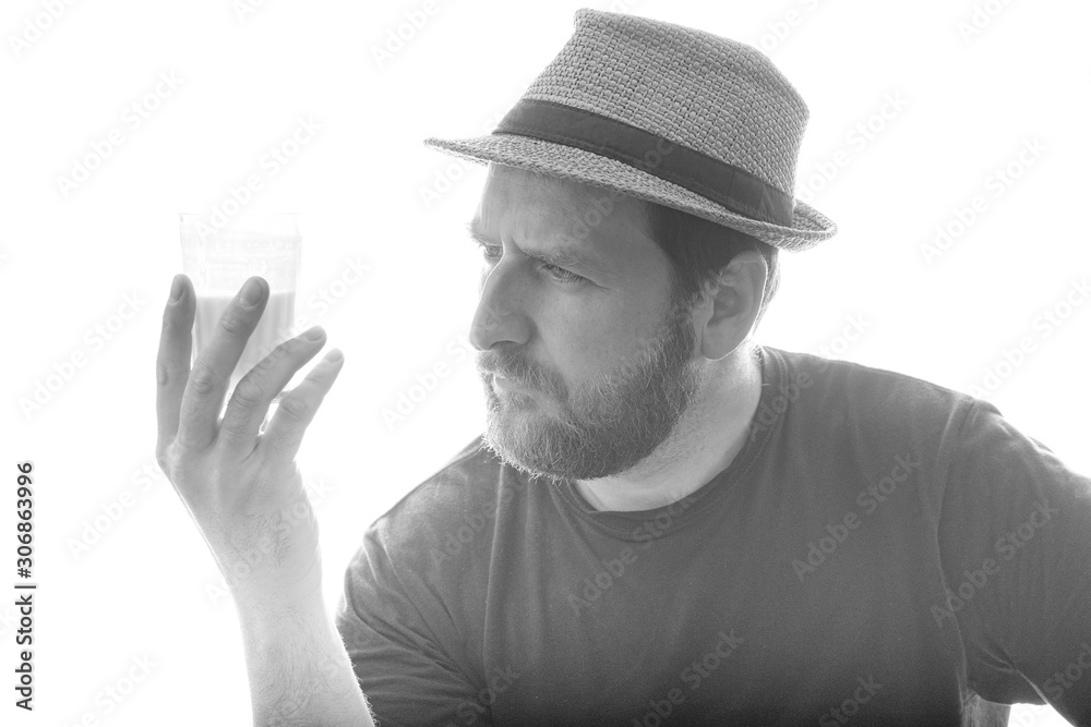 a man considers in his hand a glass of milk product black and white photo background white a man considers in his hand a glass of milk product black and white photo background white