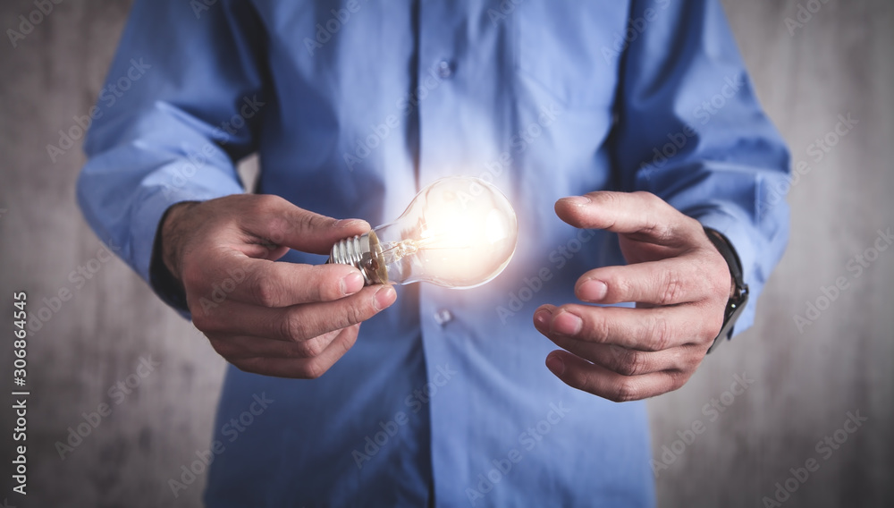 Fototapeta premium Man holding light bulb. Concept of inspiration and creativity