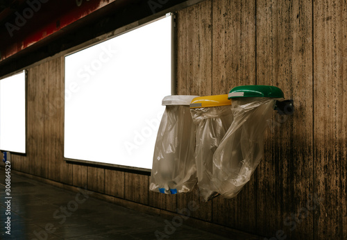 Photography Three plastic trash can standing next to each other with white billboard in the background
