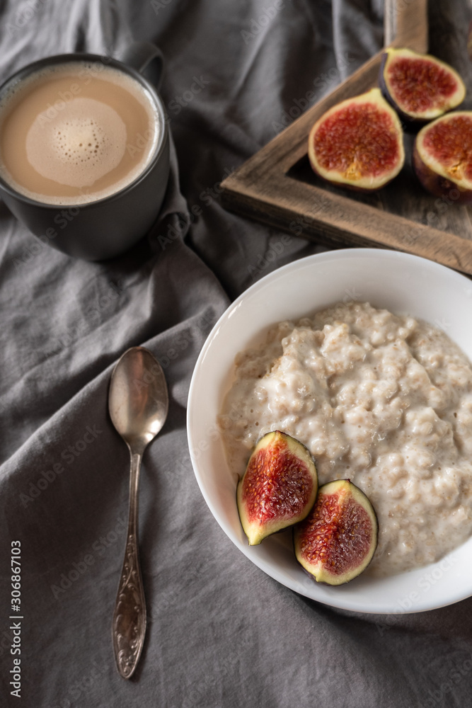 Healthy breakfast in bed. Coffee, porridge with figs, on a rustic wooden board. Clean food, alkaline diet, Healthy breakfast in bed. Coffee, porridge with figs, on a rustic wooden board. Clean food, alkaline diet,