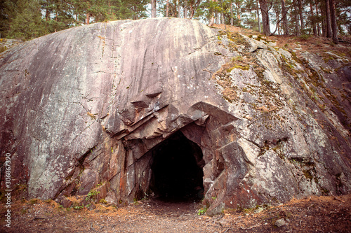 Billede på lærred Black hole in rock wall, entrance to the cave in Spro, old mineral mine